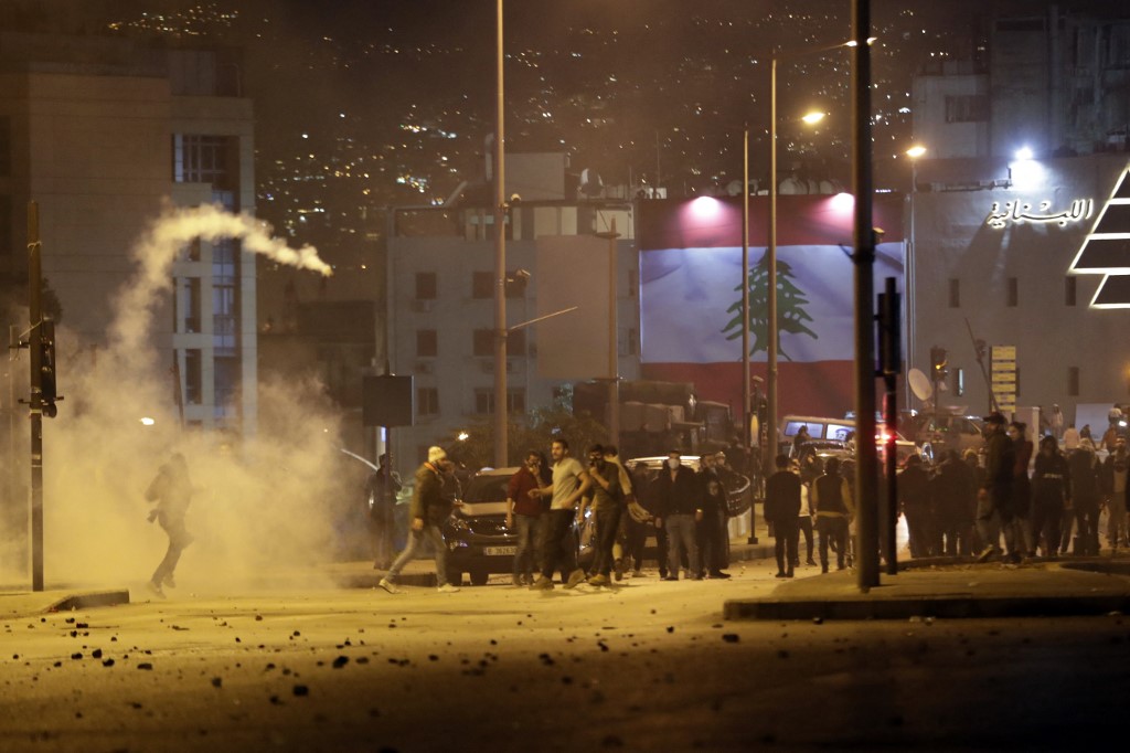 Des manifestants libanais lancent des cartouches de gaz lacrymogène sur la police anti-émeute lors d'affrontements dans la capitale Beyrouth, le 14 décembre 2019. (Photo, AFP)
