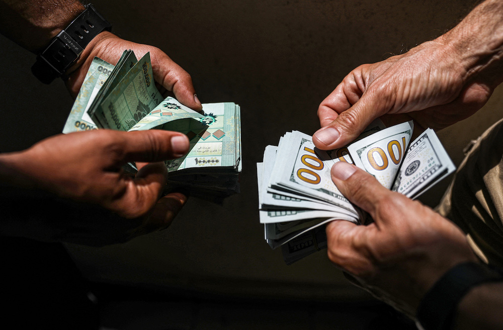 Des personnes échangeant des billets de banque en livres libanaises et en dollars américains sur le marché noir de Beyrouth, la capitale du Liban. (AFP/fichier photo)