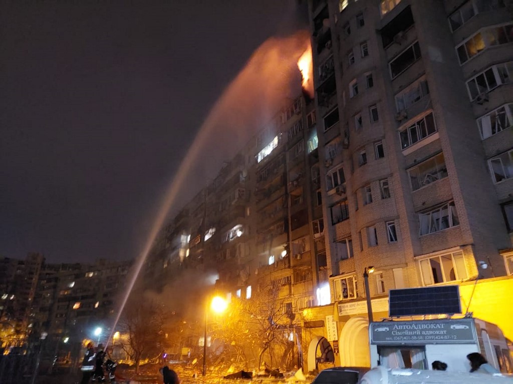 Les pompiers éteignent un incendie dans un immeuble résidentiel endommagé de la rue Koshytsa, une banlieue de la capitale ukrainienne Kiev, tôt le 25 février 2022. Les forces d'invasion russes se sont enfoncées profondément en Ukraine alors que des batailles meurtrières atteignaient la périphérie de Kiev, avec des explosions entendues dans la capitale tôt vendredi. (Photo, AFP)