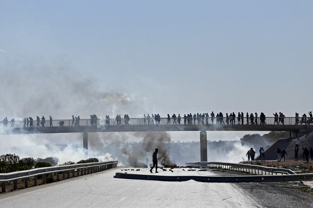 De la fumée s'échappe des gaz lacrymogènes tirés par les forces de sécurité tunisiennes dans la ville d'Agareb, dans la région centrale de Sfax, le 11 novembre 2021, deux jours après la mort d'un manifestant lors de manifestations de colère contre la réouverture d'une décharge, alors que la crise environnementale s'intensifie dans le pays d'Afrique du Nord.