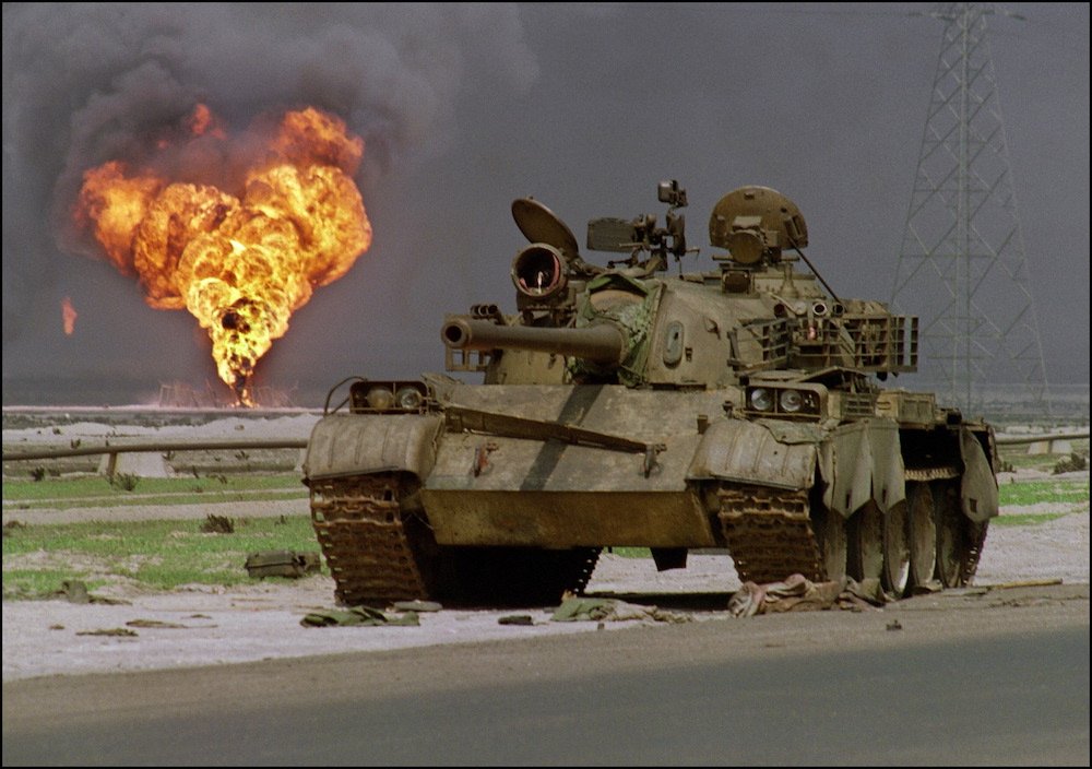 Un char T-62 irakien fabriqué par les Soviétiques a été abandonné dans le désert du Koweït le 2 avril 1991, au moment où un puits de pétrole du champ pétrolifère d'Al-Ahmadi brûle à l'arrière-plan. (AFP/File Photo)