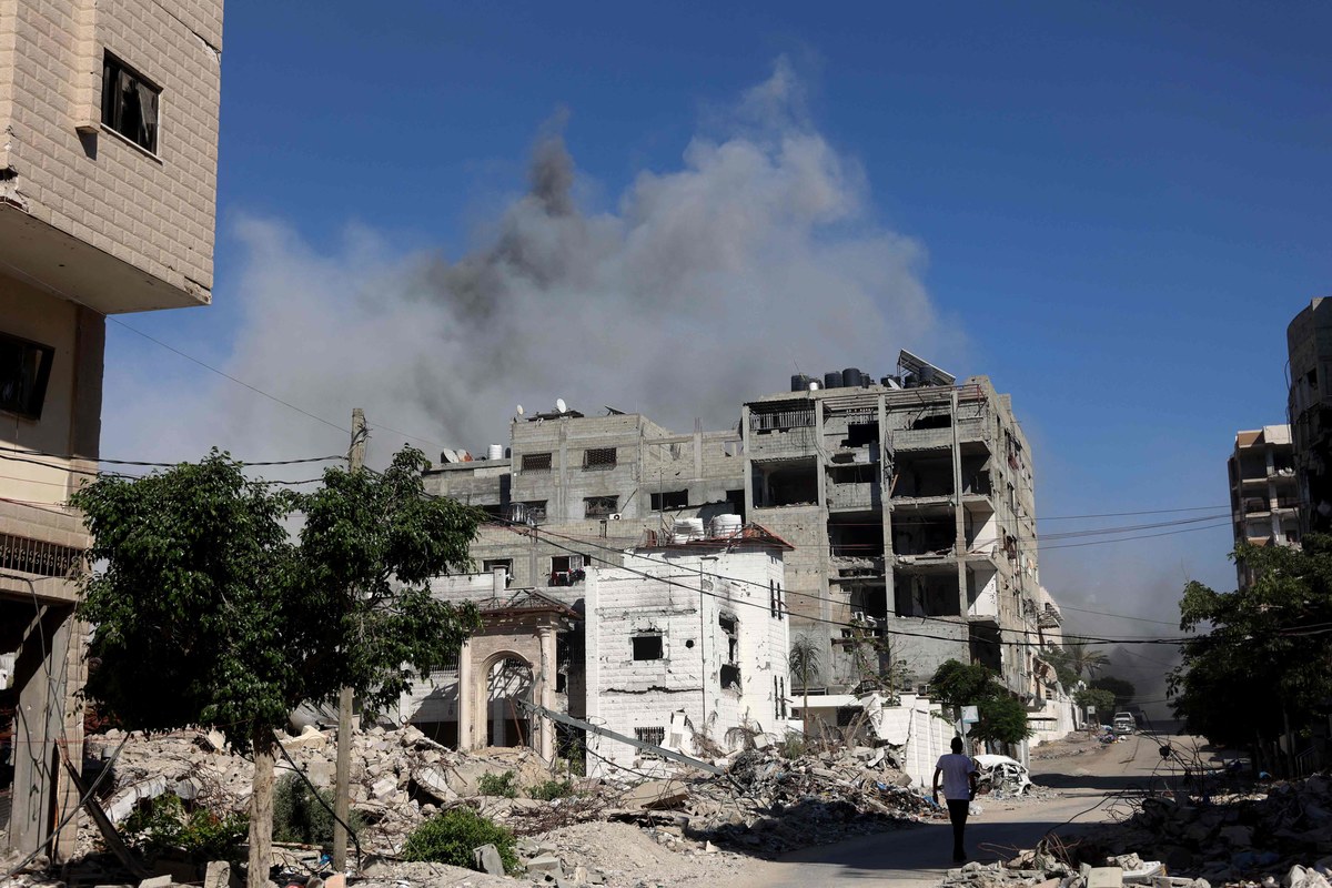 Un Palestinien marche le long d'une route devant des bâtiments endommagés lors du bombardement militaire israélien de la ville de Gaza, le 7 juillet, dans le cadre du conflit qui oppose Israël et le Hamas dans le territoire palestinien. (AFP)