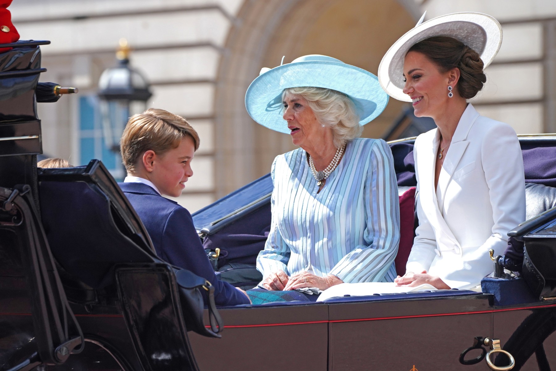 Le prince britannique George de Cambridge, la britannique Camilla, duchesse de Cornouailles et la britannique Catherine, duchesse de Cambridge quittent le palais de Buckingham, en route pour le défilé de l'anniversaire de la reine dans le cadre de Queen Célébrations du jubilé de platine d'Elizabeth II, le 2 juin 2022, à Londres (Photo, AFP).