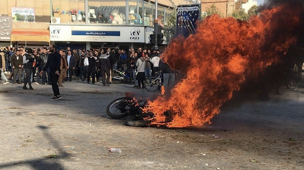 Des manifestants iraniens se rassemblent autour d'une moto en feu lors d'une manifestation contre la hausse des prix de l'essence dans la ville centrale d'Ispahan, le 16 novembre 2019. (AFP, photo)