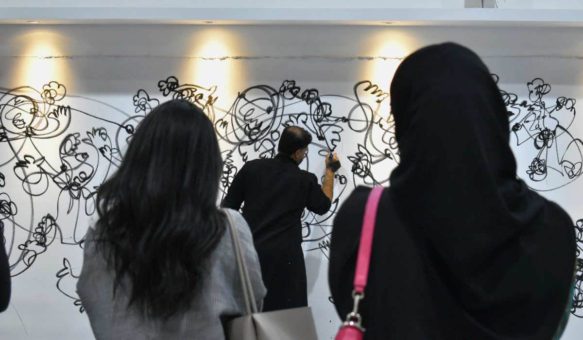 Hussain Alismail crée une nouvelle pièce sous le regard des visiteurs de son exposition W'ard à Dammam (Photo Fournie).