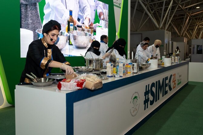 Les visiteurs et les étudiants en cuisine assistent attentivement à une séance de cuisine en direct à l’exposition internationale des pêches saoudiennes à Riyad, où se tient l’atelier MasterClass. (AN Photo/Huda Bashatah)