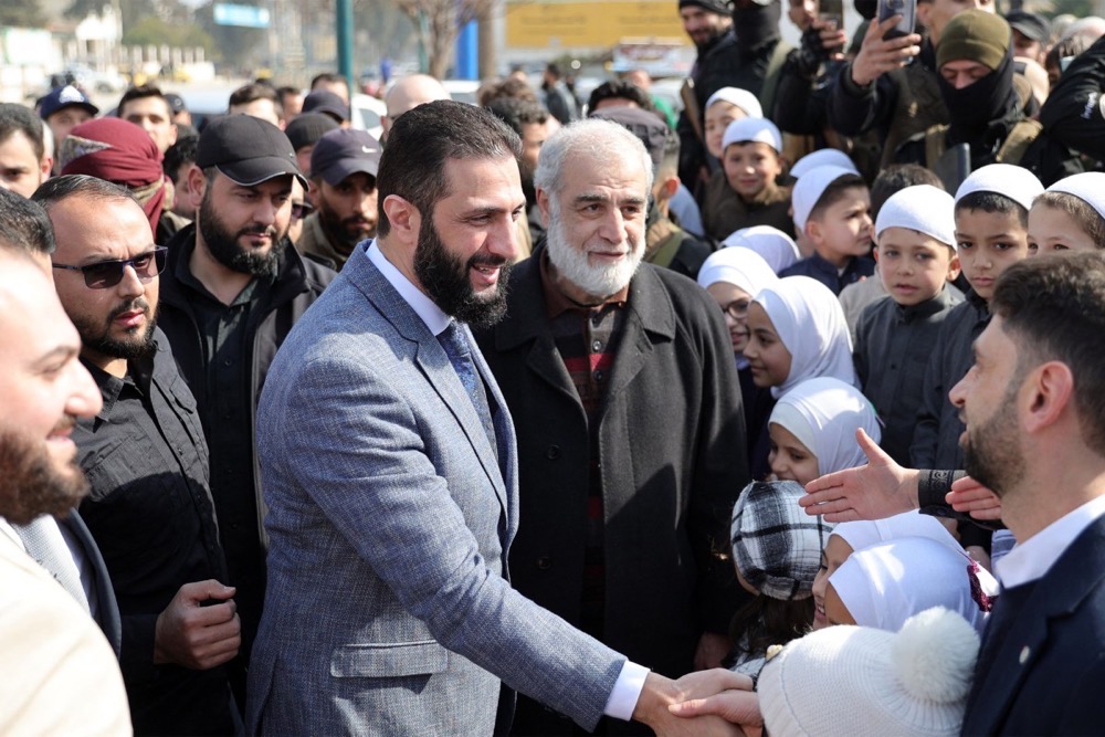 Le dirigeant intérimaire de la Syrie, Ahmed al-Sharaa, rend visite à des habitants d'un camp abritant des personnes déplacées par la guerre civile. (AFP)