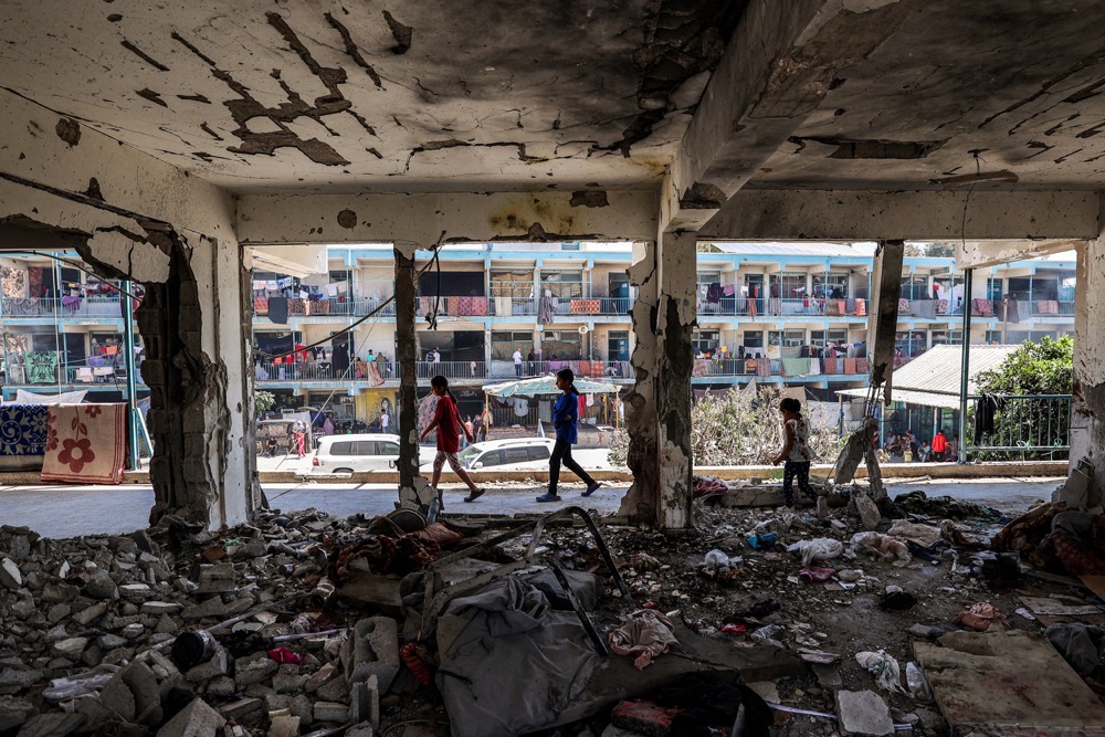 Des enfants passent devant une salle de classe détruite dans la bande de Gaza. (AFP)