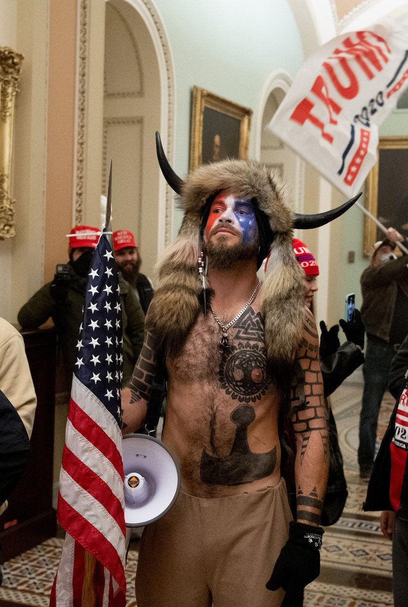 Des partisans du président américain Donald Trump, dont Jake Angeli, un partisan de QAnon connu pour son visage peint et son chapeau à cornes, manifestent au Capitole le 6 janvier 2021. (AFP/File Photo)