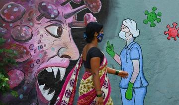 Un piéton passe devant une fresque murale représentant un personnel médical de première ligne arrêtant le coronavirus, à Navi Mumbai le 7 juin 2021 (Photo, AFP)