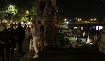 Des gens se tiennent sur les rives de la Seine après le couvre-feu Covid-19 de 23 heures, tôt le 12 juin 2021, après que des personnes se soient rassemblées à proximité, aux Invalides, pour une fête en plein air non autorisée 