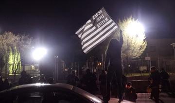 Un manifestant se tient sur une voiture et brandit un drapeau lors d'une manifestation devant le poste de police de Brooklyn Center, le 17 avril 2021 à Brooklyn Center, Minnesota (Photo, AFP)