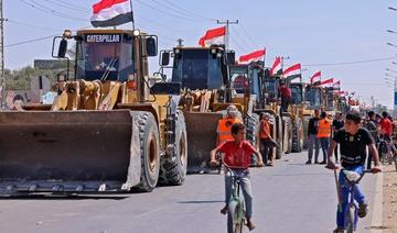 Des garçons palestiniens passent à vélo devant un convoi de bulldozers fournis par l’Égypte, alors qu’ils arrivent du côté palestinien du poste-frontière de Rafah entre l’Égypte et la bande de Gaza, le 4 juin 2021 (Photo, AFP) 