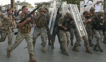 Dans cette photo d'archive du 12 septembre 2020, un soldat de l'armée libanaise, à gauche, tire en l'air pour repousser les manifestants antigouvernementaux alors que d'autres soldats se protègent des pierres, lors d'une manifestation contre le président libanais Michel Aoun près du palais présidentiel , à Baabda à l'est de Beyrouth, au Liban (Fichier/AP