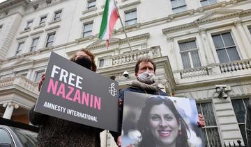 Richard Ratcliffe, époux de Nazanin Zaghari-Ratcliffe, l’Anglo-iranienne qui travaille avec une association humanitaire tenant une photo de sa femme devant l'ambassade d'Iran à Londres (Dossier/AFP) 