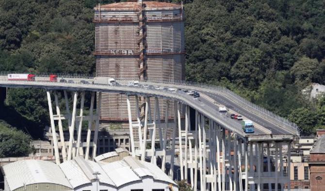 Cette vue générale prise le 15 août 2018 montre des véhicules abandonnés sur le pont autoroutier de Morandi au lendemain de l'effondrement d'une section dans la ville de Gênes, dans le nord-ouest de l'Italie. Au moins 38 personnes ont été tuées le 14 août, lorsque le pont autoroutier géant s'est effondré à Gênes, dans le nord-ouest de l'Italie.(Valéry Hache/AFP)