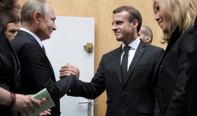 Le président russe Vladimir Poutine (g) serre la main de son homologue français Emmanuel Macron à côté de Brigitte Macron après avoir assisté à un service religieux pour l'ancien président français Jacques Chirac à l'église Saint-Sulpice à Paris, le 30 septembre 2019. Alexei Druzhinin/Spoutnik/AFP)