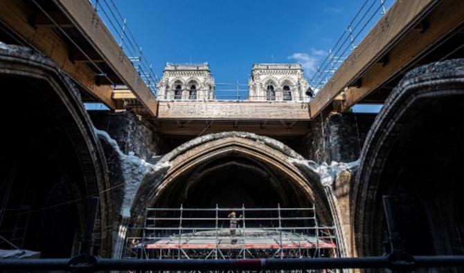 Un ouvrier se tient sur un échafaudage sous la voûte de la cathédrale Notre-Dame de Paris avant une visite du président français deux ans après l'incendie qui a fait s'effondrer la flèche et détruit une grande partie du toit, à Paris le 15 avril 2021 (Photo, AFP)