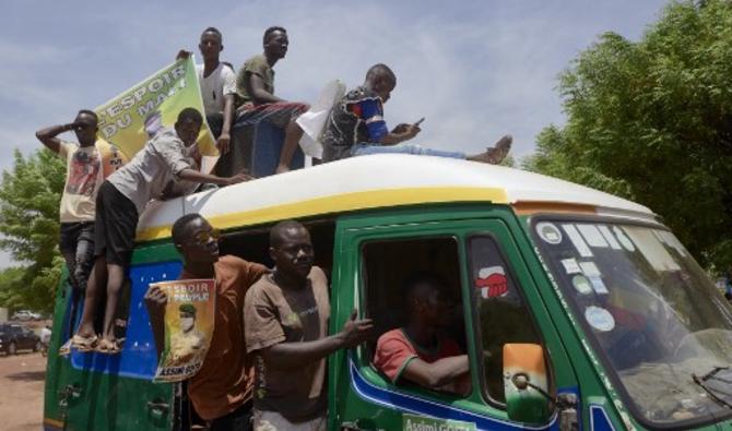 Des partisans célèbrent l'arrivée du président du gouvernement de transition du Mali, Assimi Goita, à son retour d'Accra après une réunion avec les représentants de la CEDEAO (Communauté économique des États de l'Afrique de l'Ouest) le 31 mai 2021. (Michèle Cattani/AFP)