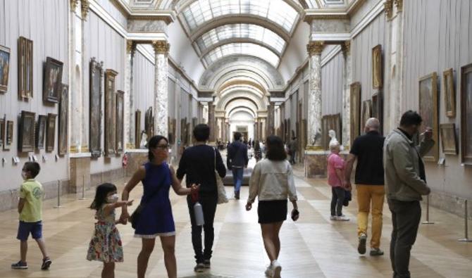 Dans cette photo d'archive prise le 06 juillet 2020, des visiteurs portant des masques faciaux circulent au musée du Louvre à Paris, le jour de la réouverture du musée. Le Premier ministre français Jean Castex a annoncé le 16 juin 2021 que les masques ne seront plus obligatoires hors de France à partir du 17 juin 2021.(François Guillot / AFP)