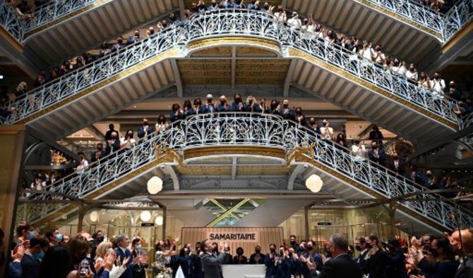 Le président français Emmanuel Macron (C) et les employés du grand magasin emblématique de Paris La Samaritaine applaudissent lors d'une cérémonie marquant la réouverture du magasin après 16 ans de fermeture, le 21 juin 2021 à Paris (Photo, AFP)