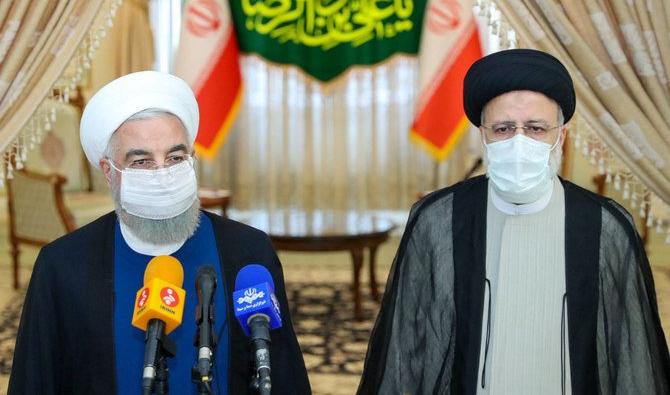 Le président iranien Hassan Rouhani, (g), se joint au président élu Ebrahim Raïssi lors d'une conférence de presse pour féliciter ce dernier pour sa victoire dans une élection dans laquelle la plupart des rivaux importants ont été exclus. (AFP)