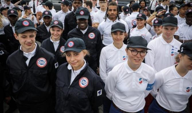 Des membres du service civique et du service national universel SNU (Service National Universel) posent à la fin du défilé militaire annuel du 14 juillet sur l'avenue des Champs-Élysées à Paris le 14 juillet 2019. (Ludovic Marin / AFP / Pool)