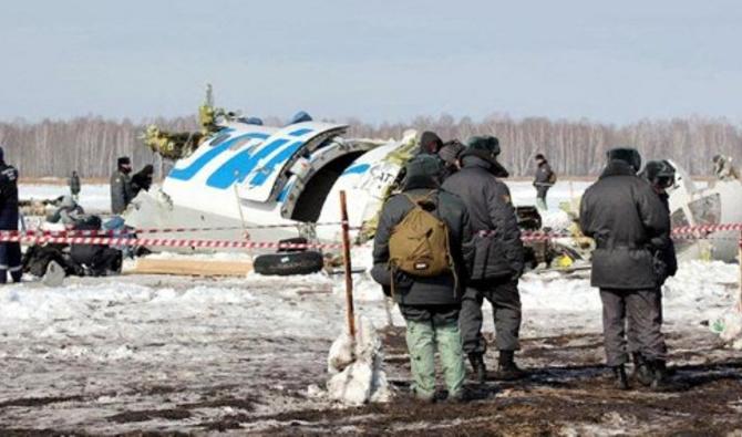 Une photo fournie le 2 avril 2012 par le département régional de Tioumen du ministère russe des Urgences montre des policiers debout près des débris d'un avion de ligne ATR-72 de fabrication franco-italienne de la compagnie aérienne privée russe UTair, sur le site de l'accident d'avion, à environ 45 km (28 miles) de la ville sibérienne occidentale de Tioumen. (AFP Photo/STR/Ministère russe des Urgences)