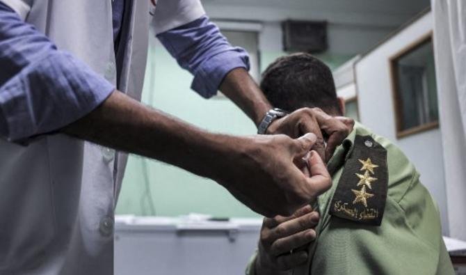 Un infirmier administre une dose du vaccin Pfizer-BioNTech à un membre palestinien de la police militaire fidèle au Hamas, dans un centre médical de la ville de Gaza, le 23 août 2021 (Photo, AFP)