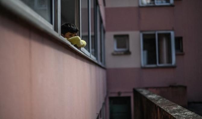 Un garçon regarde par une fenêtre, alors que des familles de réfugiés afghans viennent d'arriver après leur évacuation de Kaboul à Villeurbanne, près de Lyon, le 31 août 2021 (Photo, AFP)