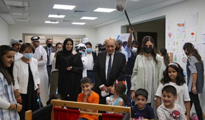 Le ministre français des Affaires étrangères Jean-Yves Le Drian, accompagné de la ministre adjointe des Affaires étrangères du Qatar Lolwah al-Khater, rend visite à des réfugiés afghans dans un complexe de logements à Doha le 13 septembre 2021 (Photo, AFP)