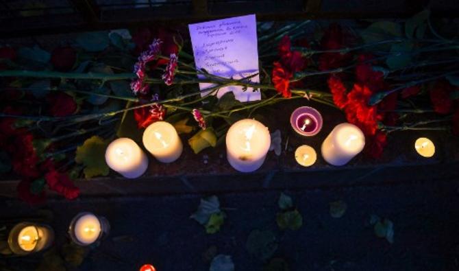 Dès la matinée, froide et brumeuse, les habitants sont venus se recueillir et déposer des fleurs et des bougies près d'une des entrées du campus de cette cité de l'Oural (Photo, AFP)