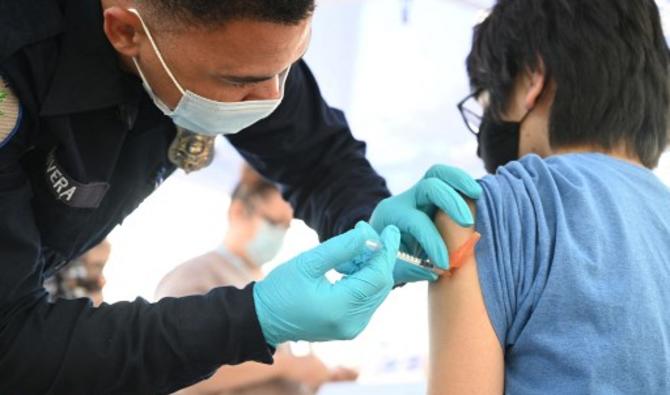 Brandon Rivera, un technicien médical d'urgence du comté de Los Angeles, donne une deuxième dose de vaccin Pfizer-BioNTech à Aaron Delgado, 16 ans, le 23 août 2021 (Photo, AFP)