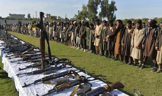 Sur cette photo prise le 17 novembre 2019, des membres du groupe Daech se tiennent devant leurs armes, après leur reddition au gouvernement afghan, à Jalalabad. (Fichier/AFP) 