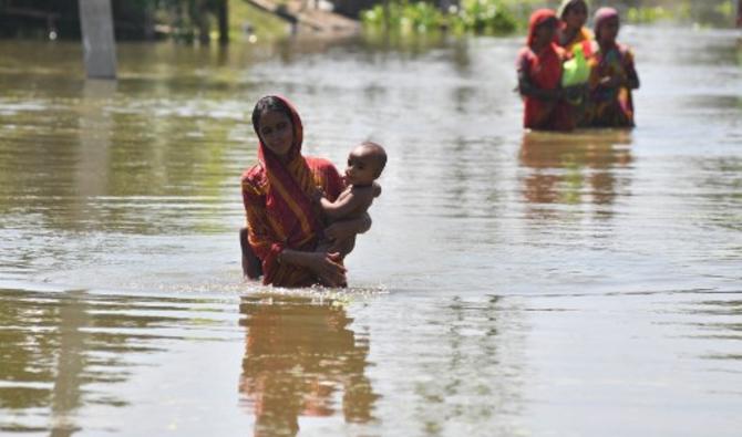 Une femme porte son enfant dans le district de Morigaon, dans l'État indien d'Assam, le 31 août 2021 (Photo, AFP)