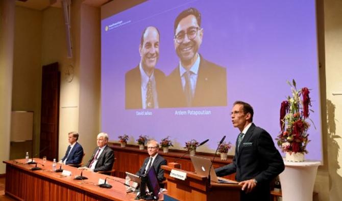 Thomas Perlmann, le secrétaire du Comité Nobel, se tient à côté d'un écran affichant les lauréats du Prix Nobel de physiologie ou médecine 2021 David Julius (L) et Ardem Patapoutian, lors d'une conférence de presse à l'Institut Karolinska de Stockholm, Suède, le 4 octobre 2021 (Photo, AFP) 