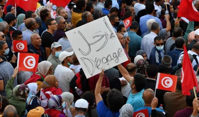 Des Tunisiens brandissent des drapeaux nationaux lors d'un rassemblement contre leur président le long de l'avenue Habib Bourguiba dans la capitale Tunis, le 10 octobre 2021 (Photo, AFP)