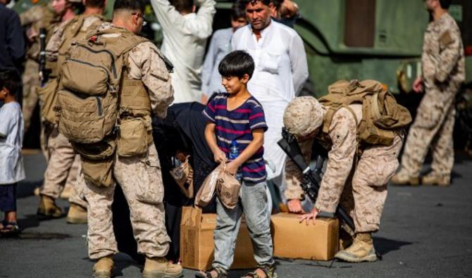 Les Marines distribuent de la nourriture aux évacués dans la zone de confort de l'aéroport international Hamid Karzai, à Kaboul, en Afghanistan, le 19 août 2021 (Photo, AFP)