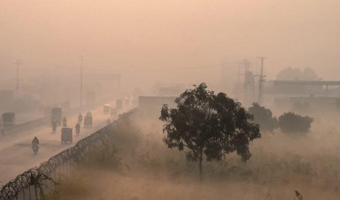 Les gens font la navette le long d'une rue dans des conditions de smog intense à Lahore, le 18 novembre 2021. (Photo, AFP)