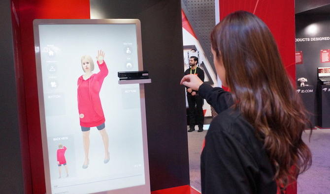 Une employée du géant chinois de la technologie JD.com montre un système de réalité augmentée qui permet aux clients d’essayer virtuellement des vêtements dans les boutiques. (AFP) Une employée du géant chinois de la technologie JD.com montre un système de réalité augmentée qui permet aux clients d’essayer virtuellement des vêtements dans les boutiques. (AFP) 