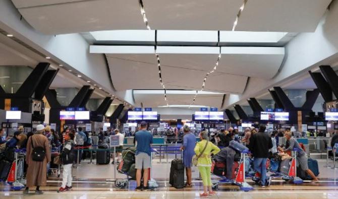 Des voyageurs font la queue à un comptoir d'enregistrement à l'aéroport international OR Tambo de Johannesburg, le 27 novembre 2021. (Photo, AFP)