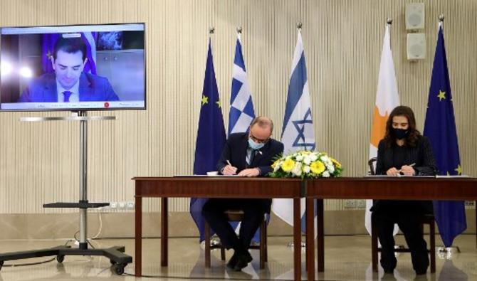 Une photo fournie par le Bureau de presse et d'information (PIO) du gouvernement chypriote le 8 mars 2021 montre (de gauche à droite) le ministre grec de l'environnement et de l'énergie Kostas Skrekas (vidéoconférence), le ministre israélien de l'énergie Yuval Steinitz et le ministre chypriote de Énergie, Commerce et Industrie, Natasa Pilides, signant un protocole d'accord sur la coopération en relation avec le projet EuroAsia Interconnector. (Photo, AFP)