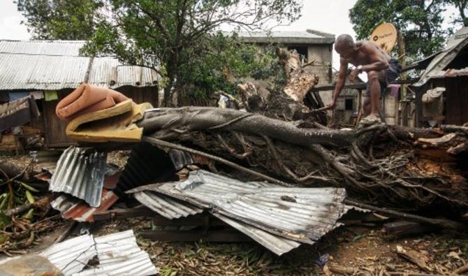 Jocelyn Germain (56 ans) abat un arbre à la hache tombé sur la maison de son fils suite au passage du cyclone Batsirai, le 8 février 2022 à Irondro. (Photo, AFP)