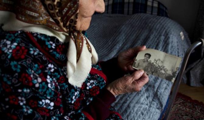 Une Ukrainienne de 98 ans, Rozalia Tchoba, qui a passé dix ans en Sibérie en tant que prisonnière politique, montre une vieille photo d'elle, chez elle dans le village de Solonka, à l'extérieur de Lviv, dans l'ouest de l'Ukraine, le 8 mars 2022. (Photo, AFP)