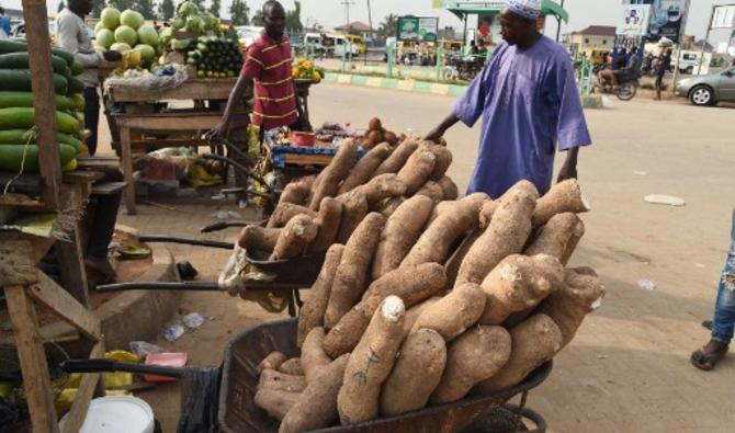 Des vendeurs ambulants présentent des ignames et des fruits à vendre à Lagos, la capitale commerciale du Nigeria, le 14 mars 2022. (Photo, AFP)