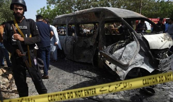 La police inspecte les lieux aux abords de véhicules endommagés à la suite d'un attentat suicide près de l'Institut de Chine de l'Université de Karachi, qui a fait au moins quatre morts, le 26 avril 2022. (Photo, AFP)