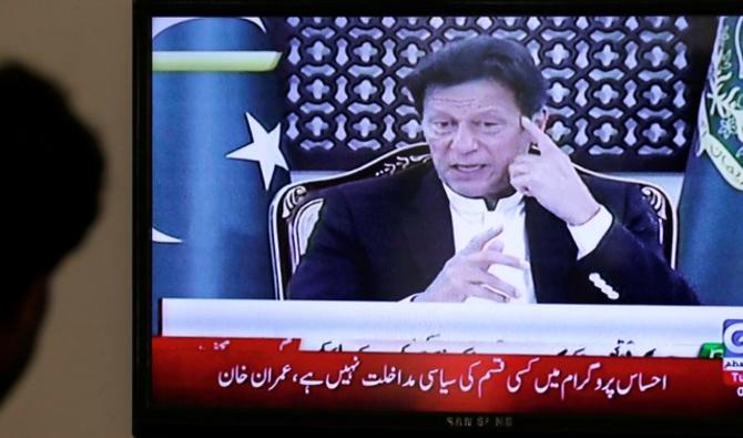 Les Pakistanais regardent Imran Khan faire un discours à la nation. (Reuters)