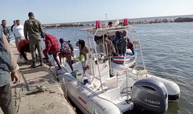 Un garde-côte national tunisien aide des migrants à descendre d'un bateau de sauvetage à Jbeniana, Safx, Tunisie le 23 avril 2022. (Capture d'écran, Reuters)