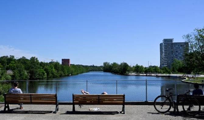 Les gens profitent du soleil sur des bancs lors d'une vague de chaleur à Rennes, dans l'ouest de la France, le 10 mai 2022. (Photo, AFP)