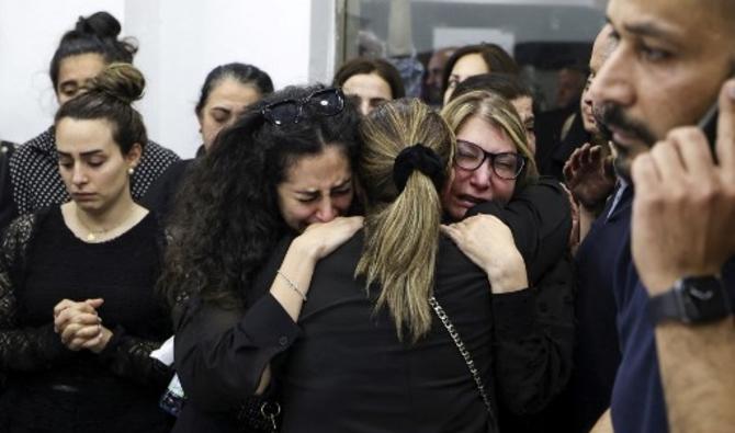 Des collègues se prennent dans les bras lorsque le cadavre de la journaliste chevronnée d'Al-Jazeera Shireen Abu Akleh est amené dans les bureaux de la chaîne d'information dans la ville de Ramallah, en Cisjordanie, le 11 mai 2022. (Photo, AFP)